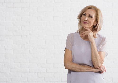Não quer mais lidar com os incômodos da menopausa smiley-velha-olhando-para-longe-com-fundo-de-tijolo.jpg